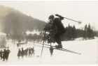 Czarno białe zdjęcie narciarza z kijkami na stoku