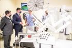 Grupa osób podczas prezentacji urządzenia w szpitalnym pomieszczeniu, na pierwszym planie masywny robot da Vinci