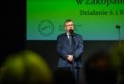 Marszałek Małopolski Witold Kozłowski przemawia na scenie na tle grafiki teatru