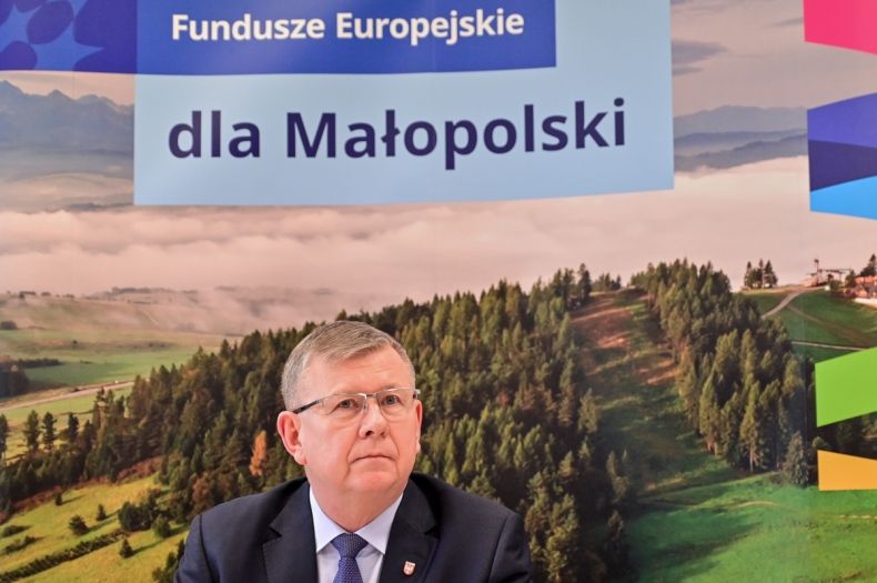 marszałek witold kozłowski na tle napisu Fundusze Europejskie dla Małopolski